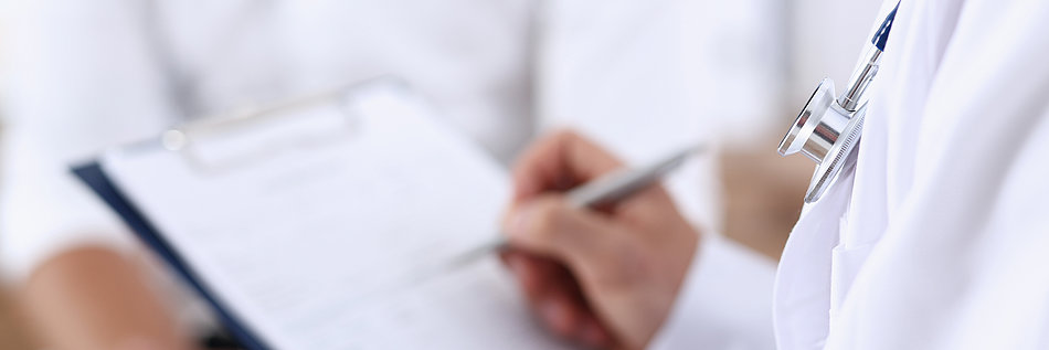 Arzt hält ein Klemmbrett und einen Stift in der Hand und macht Notizen