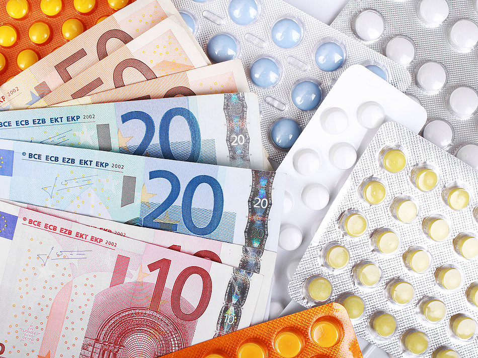 Fächer aus Euroscheinen bedeckt verschiedene Medikamenten-Blister