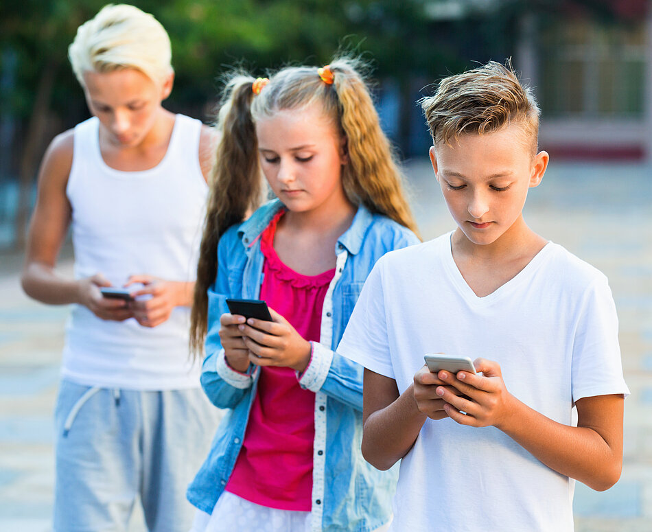 Kinder nutzen Handy Eine Gruppe aus Kindern nutzt das Handy
