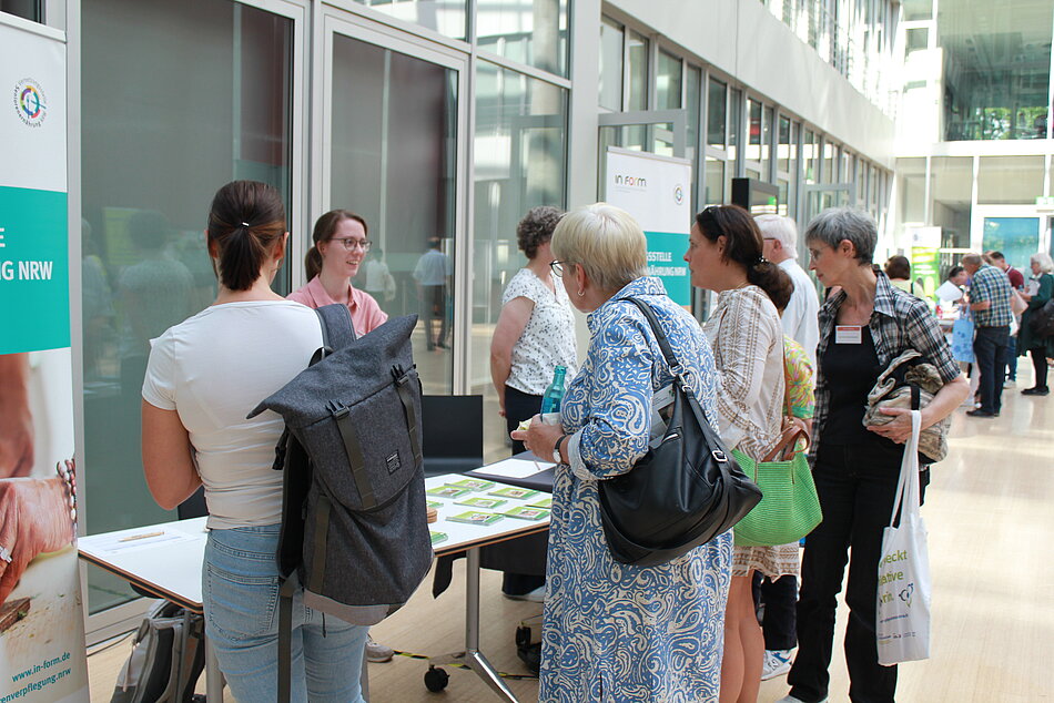 Infostand bei der Veranstaltung zu Einsamkeit im Alter mit Besuchern.