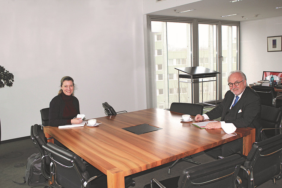 Sandra Postel und Rudolf Henke sitzen am Besprechungstisch.