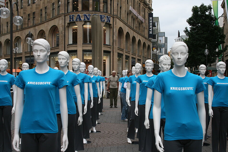 Schaufensterfiguren mit blauen Shirts mit der Aufschrift "Kriegsbeute"