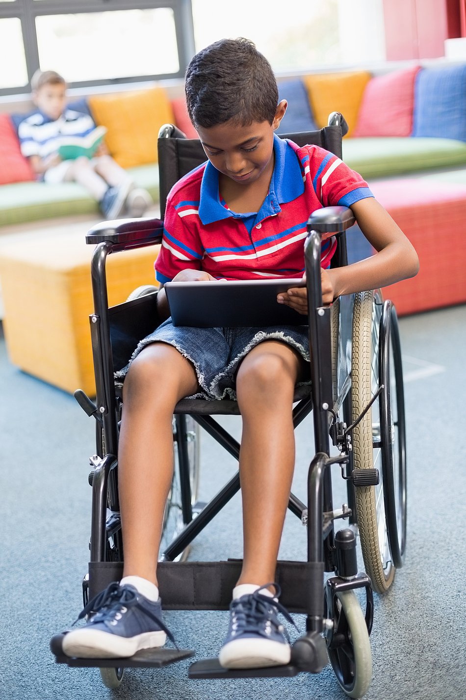 Junge im Rollstuhl mit Tablet