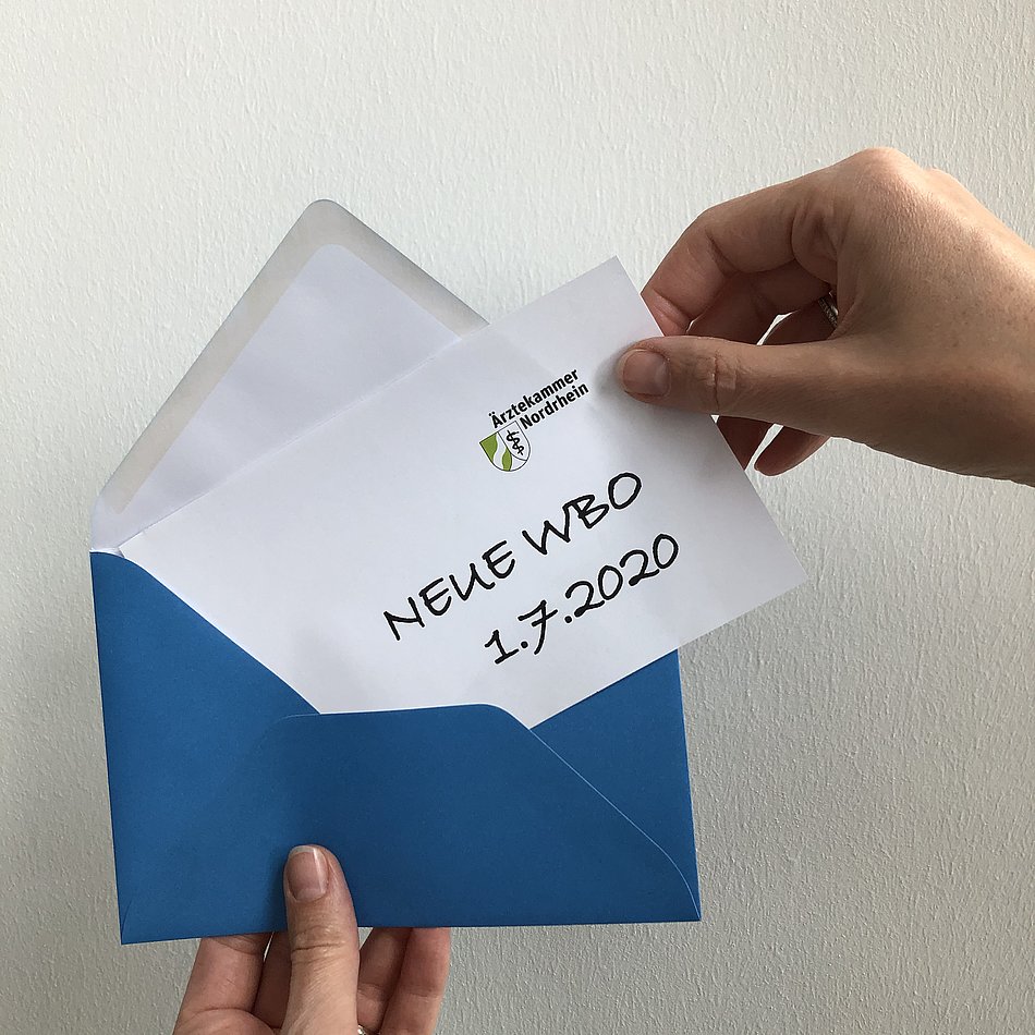 Eine Hand zieht aus einem Umschlag einen Zettel mit dem Titel "Neue WBO 1.7.2020"