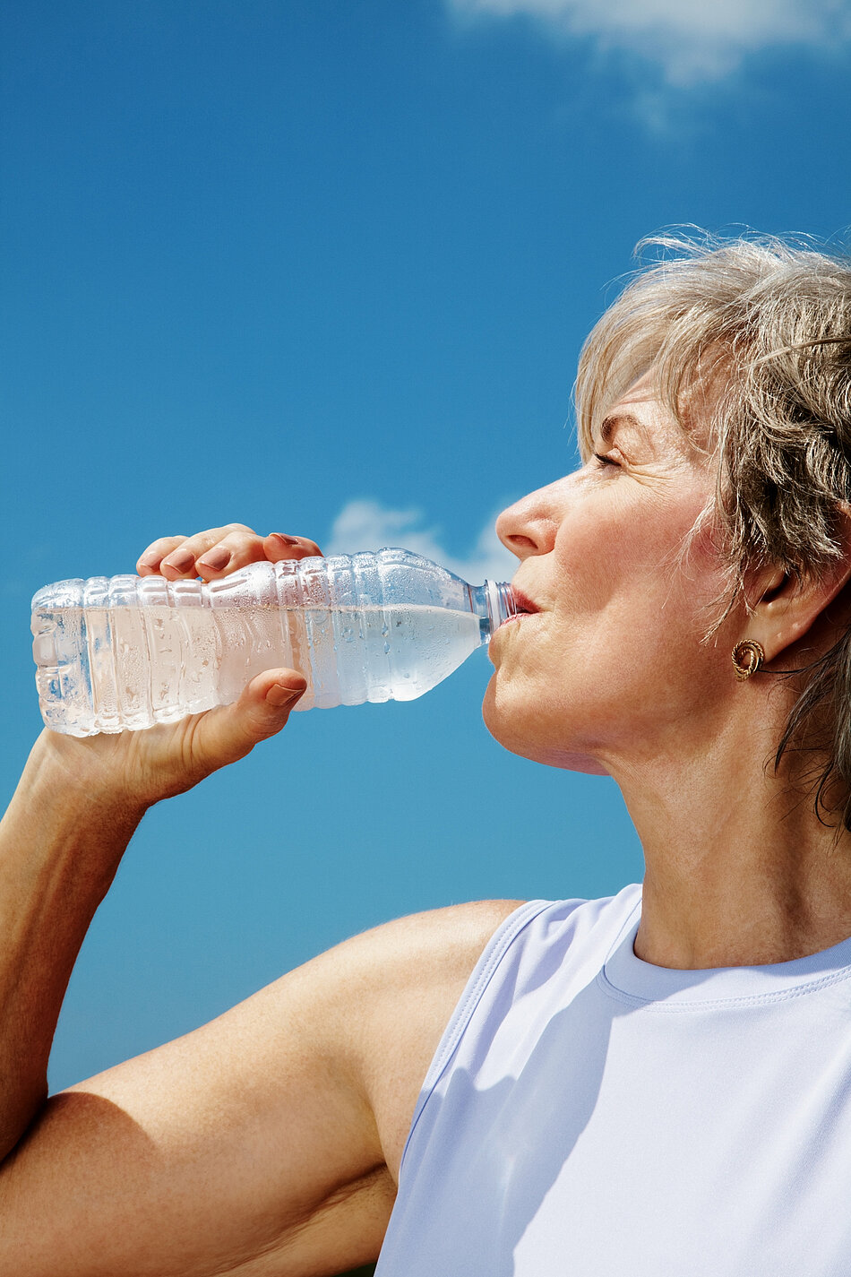 Frau trinkt Wasser aus der Flasche.