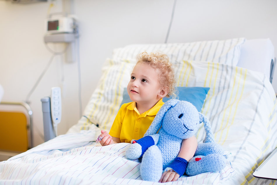 Kleiner Junge sitzt im Krankenhausbett