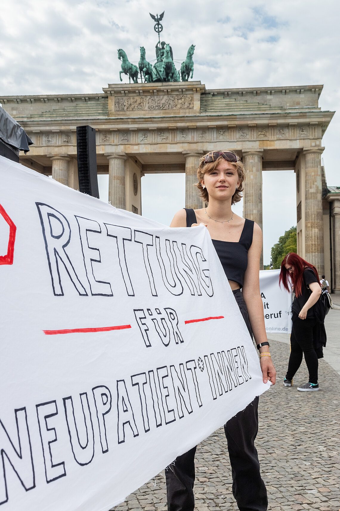 Protest in Berlin Person mit Banner auf einer Demo